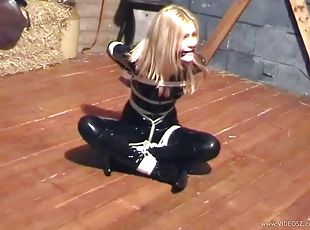 Latex-clad blonde with big tits tied up with chains and ropes