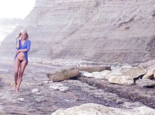 Desirable blonde strips while walking on the deserted beach