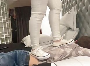 Trampling with white sneakers in bed