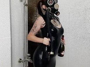 Backstage from the Halloween shoot. Mistress in a gas mask and latex is doused with wine